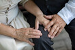 © st.kolesnikov - hands of elderly people holding hands close up