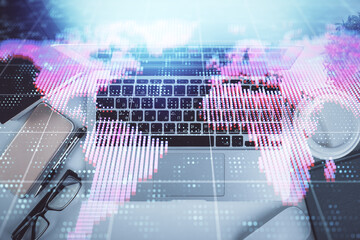 Fototapete - Business theme hologram drawings over computer on the desktop background. Top view. Multi exposure. Concept of international connections.
