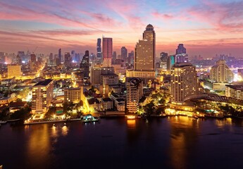 Wall Mural - Sunrise scenery of Bangkok City in bird's eye view~ Aerial panorama of Bangkok in morning twilight, with rosy clouds in the sky, light trails on Chao Phraya River & modern skyscrapers by the canal