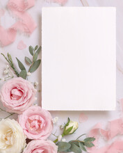Blank Paper Card Between Pink Roses And Pink Silk Ribbons On Marble Top View, Wedding Mockup