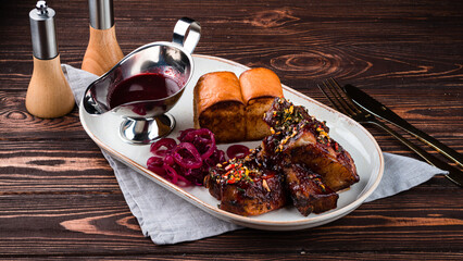 Canvas Print - Smoked pork breast in sauce and spices with pickled onions, sauce and bread.