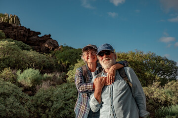 Sticker - Smiling old senior couple enjoying outdoor excursion in mountain environment. Beautiful active elderly people having healthy lifestyle in retirement