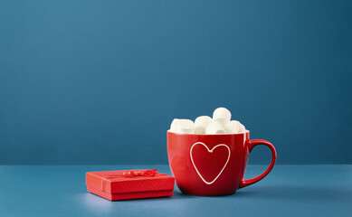 Wall Mural - Small red gift box and big mug with heart and marshmallows on blue background. Happy St Valentines sweet gift. Thank you. Mothers Day. Love