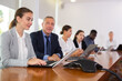 © JackF - Senior white male colleague training young white female employee, helping her prepare financial report and other documents on laptop while sitting in office boardroom