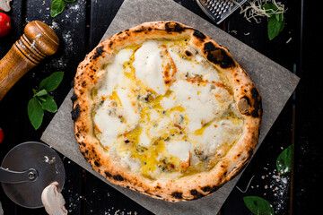 Canvas Print - Italian food pizza with different types of cheese parmesan, blue cheese, mozzarella on a thick dough from oven.