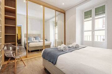 Poster - A double bedroom with a large wardrobe covering one wall with oak wood edged sliding mirror doors