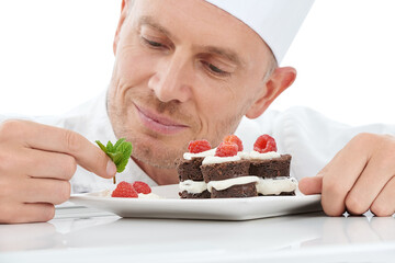 Wall Mural - Dessert, plate and chef in a studio cooking with mint for a sweet treat, snack or craving. Culinary, food industry and man baker baking a delicious cake with fruit while isolated by white background.