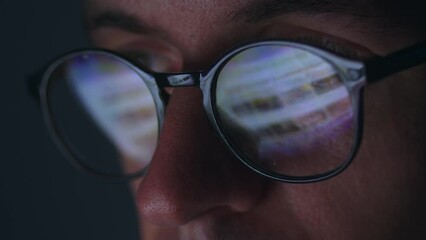 Double exposure monitor screen reflection in eyeglasses. Close up portrait business man in eyeglasses using internet, scrolling web pages, working online late at night time