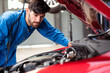 © winnievinzence - Caucasian auto mechanic young man checking and repairing car radiator bonnet in automotive condition in garage at auto repair shop, motor technician working after vehicle service maintenance concept