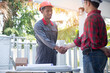 © weerachai - Engineers handshake with architects at the village project construction site.concept business