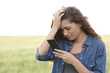 © Antonioguillem - Sad woman checking phone in a wheat field