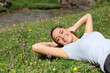 © Antonioguillem - Relaxed woman on the grass in a riverside