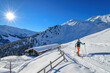 © Westend61 - Austria, Tyrol, Sun shining over female skier walking past secluded hut in Tux Alps