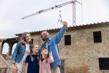 Happy Man Taking Selfie With Family In Front Of House