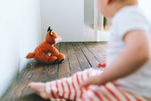 A Baby Boy Looks At A Stuff Toy Fox