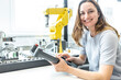 © Westend61 - Female skilled worker in robotic factory controlling robot arm with digital control