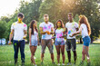 © oneinchpunch - Multiethnic group of happy playful friends playing and having fun with holi colorful powder at the park