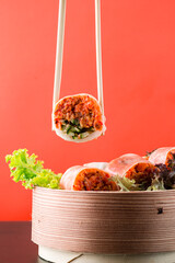 Wall Mural - Rice paper rolls with tuna, cucumber, flying fish roe and lettuce on a red.