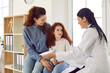 © Studio Romantic - Cute little preteen girl with smiling mom at reception in pediatrician office at medical clinic. Friendly female doctor fills out child's medical card before medical examination. Concept of pediatrics