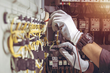 Wall Mural - Electrician engineer tests electrical installations and wires on relay protection system.