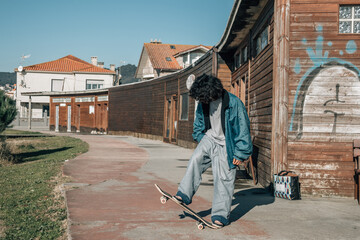 casual latin boy with skateboard in the street