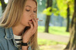 © New Africa - Young woman smoking cigarette outdoors on sunny day. Space for text