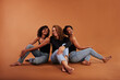 © Flamingo Images - Stylish group of diverse friends laughing on an orange background