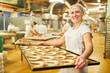 © Robert Kneschke - Frau trägt Backblech mit Croissants in der Großbäckerei