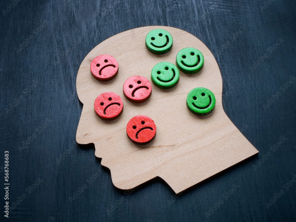 Head with sad and happy smileys. Psychology, mood and emotions concept.