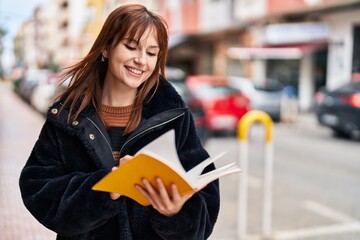 Sticker - Young woman smiling confident reading book at street