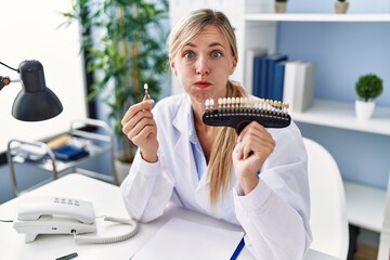 Canvas Print - Beautiful dentist woman comparing teeth whitening puffing cheeks with funny face. mouth inflated with air, catching air.