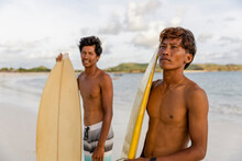 Indonesia, Lombok, Portrait Of Two Surfers Standing On Beach