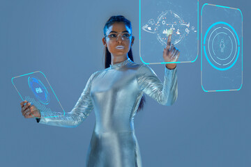 A model dressed as a robot wearing silver, futuristic  clothes holding a virtual  tablet, with virtual icons . A future technology concept