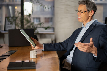 Portrait of businessman in office. Man using digital tablet. Businessman having video call..