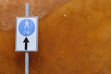 Road sign with ochre wall behind