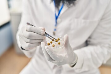 Sticker - Young african american man wearing scientist uniform using tweezer at laboratory