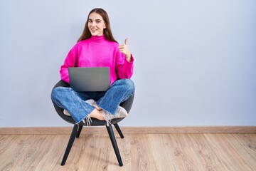 Poster - Young hispanic girl working using computer laptop doing happy thumbs up gesture with hand. approving expression looking at the camera showing success.