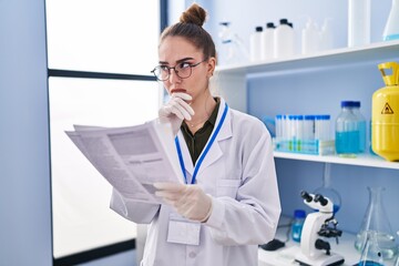 Poster - Young woman scientist reading document at laboratory