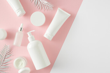 Wall Mural - Summer skincare concept. Top view photo of cosmetic tubes, dropper bottle, pump bottle and tropical leaves on pastel pink and white background with empty space. Flat lay cosmetics mockup idea.