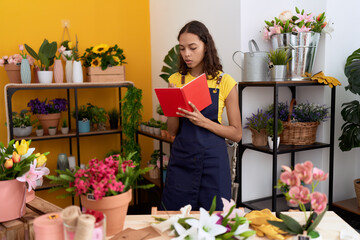 Wall Mural - Young african american woman florist writing on notebook standing at flower shop