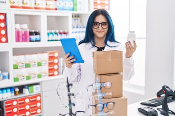 Sticker - Young caucasian woman pharmacist using touchpad holding pills bottle at pharmacy