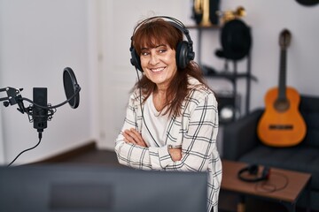 Sticker - Middle age woman musician smiling confident with arms crossed gesture at music studio