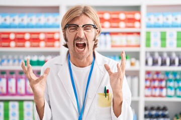 Sticker - Caucasian man with mustache working at pharmacy drugstore crazy and mad shouting and yelling with aggressive expression and arms raised. frustration concept.