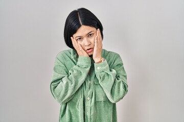 Canvas Print - Young asian woman standing over white background tired hands covering face, depression and sadness, upset and irritated for problem