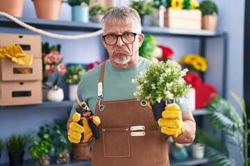 Poster - Hispanic man with grey hair working at florist shop depressed and worry for distress, crying angry and afraid. sad expression.