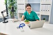 Young beautiful hispanic woman doctor eating salad working at clinic