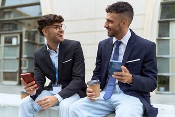 Wall Mural - Two hispanic men business workers using smartphones drinking coffee at street