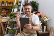 © Krakenimages.com - Hispanic man with beard working at florist shop doing video call screaming proud, celebrating victory and success very excited with raised arm