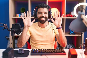 Poster - Hispanic man with beard playing video games with headphones showing and pointing up with fingers number ten while smiling confident and happy.