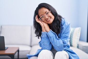 Canvas Print - Young chinese woman smiling confident sitting on sofa at home
